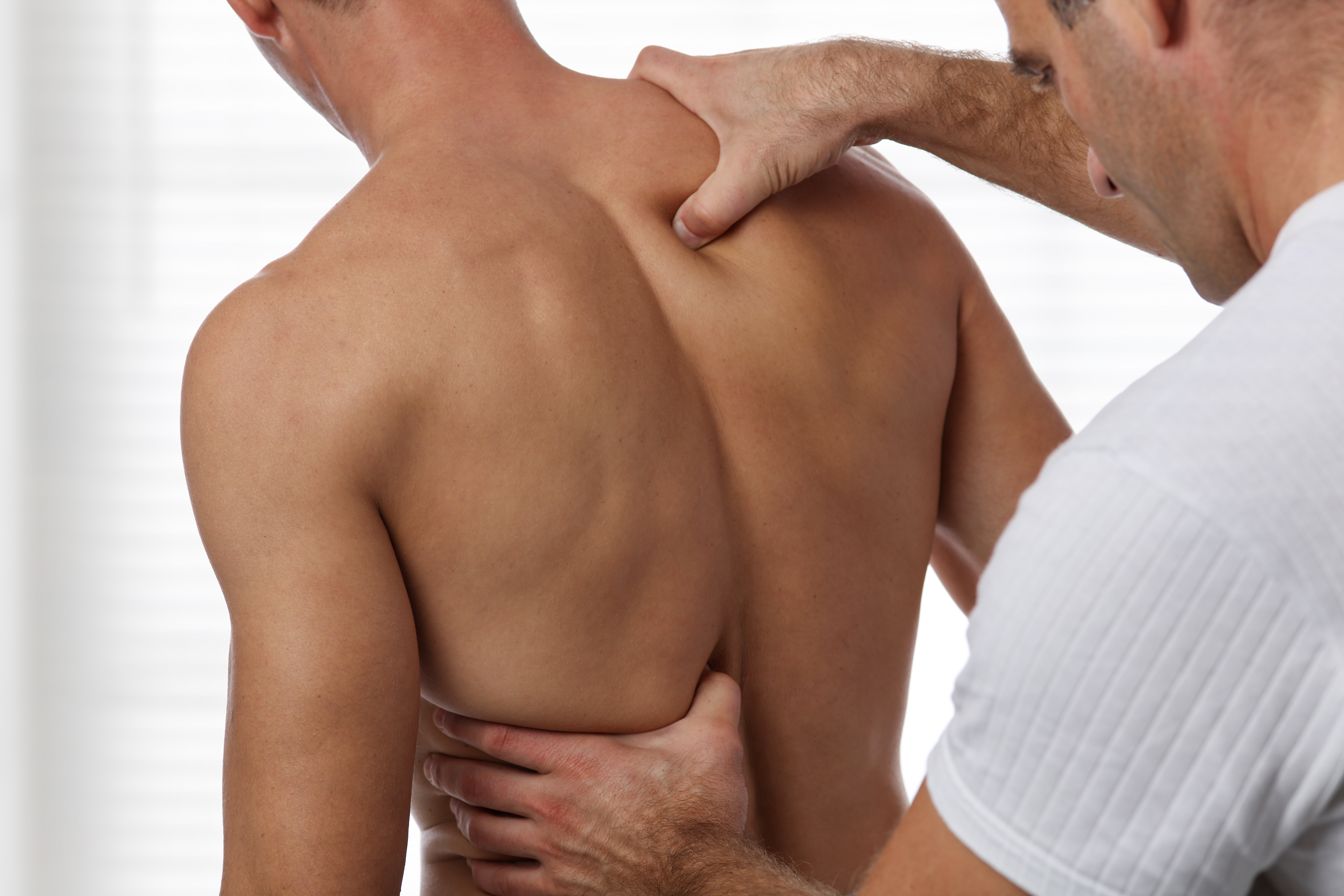 Man having chiropractic back adjustment. Osteopathy, acupressure, sport injury rehabilitation concept
